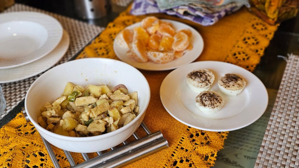 A colorful breakfast table with fruit salad, oranges, and dessert muffins for a nutritious start.