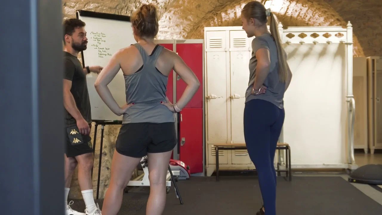 Coach échangeant avec deux participantes lors d'une séance de Small Group